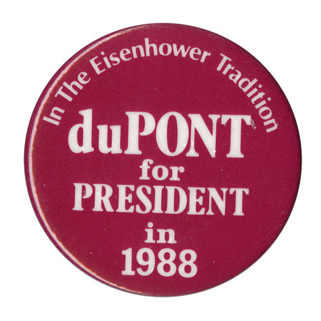 Round, red button with white text reading "In The Eisenhower Tradition duPONT for PRESIDENT in 1988"