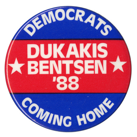 Round, red and blue button with white text reading "DEMOCRATS COMING HOME DUKAKIS BENTSEN '88"