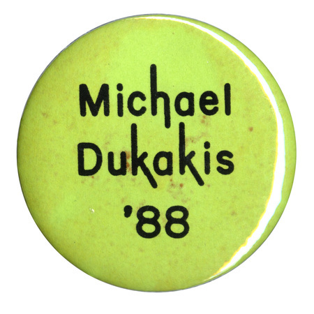 Round, green button with black text reading "Michael Dukakis '88"