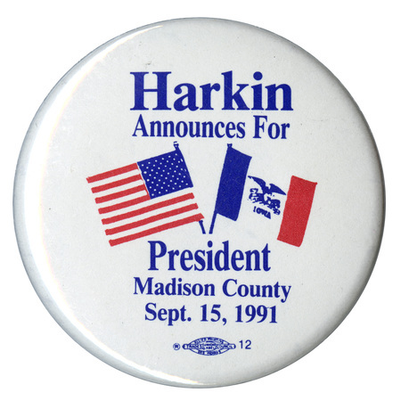 Round, white button with images of the US flag and the Iowa state flag. Blue text reads "Harkin Announces For President Madison County Sept. 15, 1991"