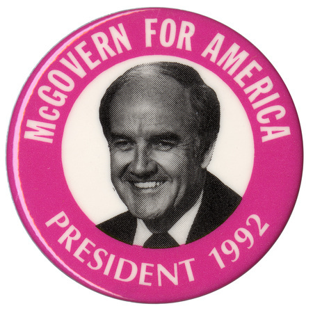 Round button with a pink border and a black and white photograph of George McGovern in a white circle in the center. White text around the edge reads "McGOVERN FOR AMERICA PRESIDENT 1992"