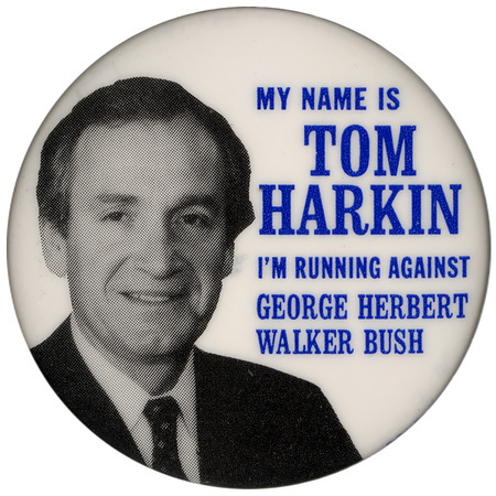 Round, white button with a black and white photograph of Tom Harkin. Blue text reads "MY NAME IS TOM HARKIN I'M RUNNING AGAINST GEORGE HERBERT WALKER BUSH"