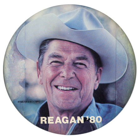 Round button with a color photograph of Ronald Reagan wearing a cowboy hat. White text reads "REAGAN '80"
