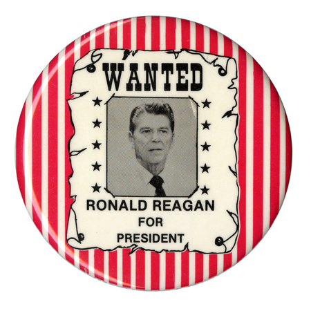 Round, red and white striped button with a drawing of a poster containing a photograph of Ronald Reagan and black text reading "WANTED RONALD REAGAN FOR PRESIDENT"