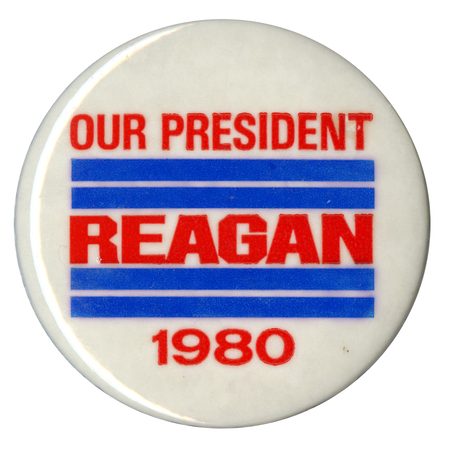 Round, white button with thick blue stripes. Red text reads "OUR PRESIDENT REAGAN 1980"