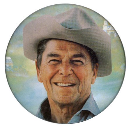Round button with a color photograph of Ronald Reagan wearing a cowboy hat.