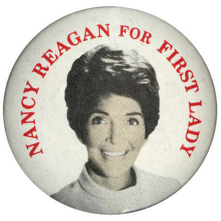 Round, white button with a color photograph of Nancy Reagan and red text reading "NANCY REAGAN FOR FIRST LADY"