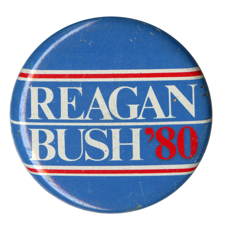 Round, blue button with white and red text reading "REAGAN BUSH '80"