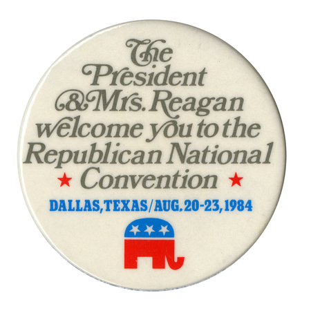 Round, white button with the GOP elephant symbol in red and blue. Gray and blue text reads "The President & Mrs. Reagan welcome you to the Republican National Convention DALLAS, TEXAS/AUG. 20-23, 1984"