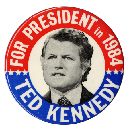 Round button with red and blue border and a black and white photograph of Ted Kennedy in the center. White text reads "FOR PRESIDENT in 1984 TED KENNEDY"