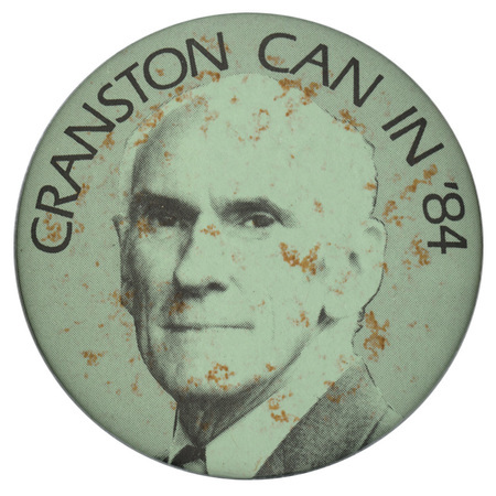 Round, gray button with a black and white photograph of Alan Cranston and black text reading "CRANSTON CAN IN '84"