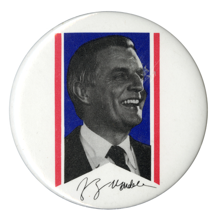 Round, white button with a black and white photograph of Walter Mondale inside of a blue and white ribbon shape. Mondale's signature appears below the ribbon in black.