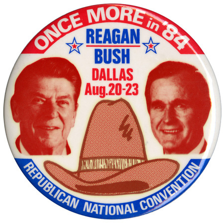 Round, blue button with a color photograph of Ronald Reagan above the Seal of the President of the United States. White and yellow text reads "RE-ELECT THE PRESIDENT 1984 RONALD REAGAN"
