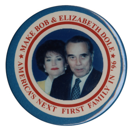 Round button with nested blue, white, and red borders. In the center is a color photograph of Elizabeth and Bob Dole. Red text reads "MAKE BOB & ELIZABETH DOLE AMERICA'S NEXT FIRST FAMILY IN '96"