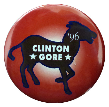 Round, red button with an illustration of a donkey's silhouette outlined in blue. White text on the donkey reads "'96 CLINTON GORE"