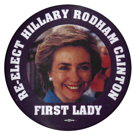 Round button with a black border around a color photograph of Hillary Clinton. White text reads "RE-ELECT HILLARY RODHAM CLINTON FIRST LADY"