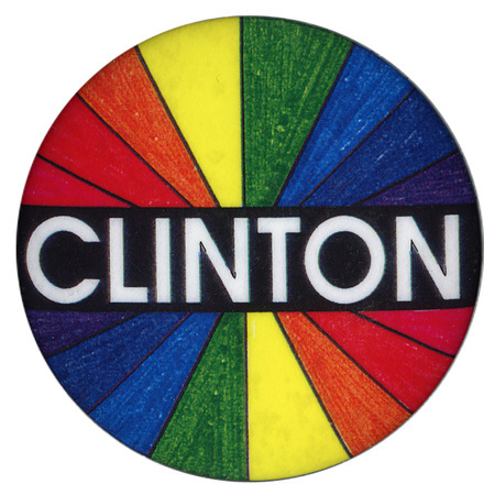 Round button with a radiating rainbow pattern. Across the middle is a black band with white text reading "CLINTON".
