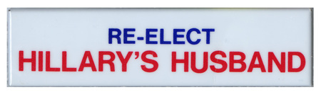 Rectangular, white button with blue and red text reading "RE-ELECT HILLARY's HUSBAND"