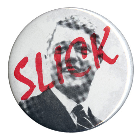 Round button with a black and white photograph of Bill Clinton. Red text across his face reads "SLICK"