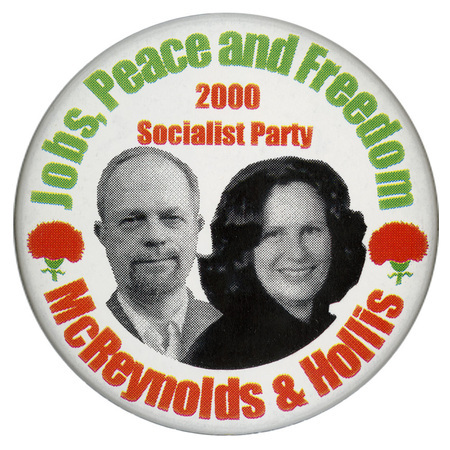 Round, white button with black and white photographs of David McReynolds and Mary Cal Hollis between two red and green carnations. Green and red text reads "Jobs, Peace and Freedom 2000 Socialist Party McReynolds & Hollis"