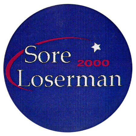 Round, blue button with white and red text reading "Sore Loserman 2000"