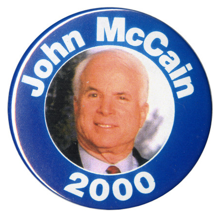 Round button with a blue border around a color photograph of John McCain. White text reads "John McCain 2000"