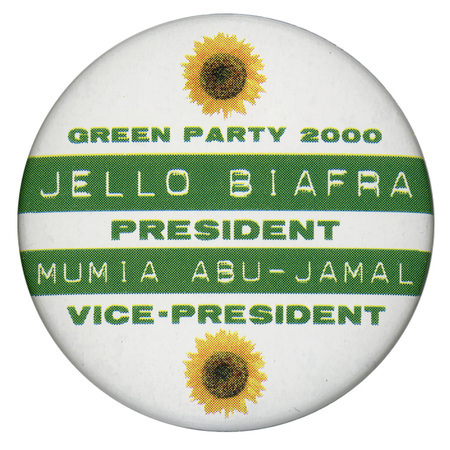 Round, white button with horizontal bands of green and two color photographs of sunflowers. Green and white text reads "GREEN PARTY 2000 JELLO BIAFRA PRESIDENT MUMIA ABU-JAMAL VICE-PRESIDENT"