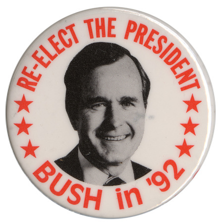 Round, white button with a black and white photograph of George H. W. Bush. Orange text reads "RE-ELECT THE PRESIDENT BUSH in '92"
