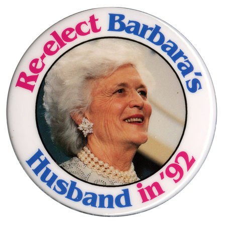 Round button with a white border and a color photograph of Barbara Bush in the center. Pink and blue text reads "Re-elect Barbara's Husband in '92"