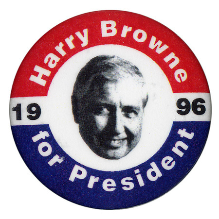 Round button with red and blue border. In the center is a black and white photograph of Harry Browne. White and black text reads "Harry Browne for President 1996"