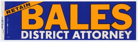 Rectangular, blue bumper sticker with yellow and white text reading "RETAIN BALES DISTRICT ATTORNEY"