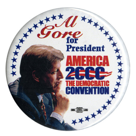 Round, white button with a border of blue stars and a color photograph of Al Gore. Red and blue text reads "Al Gore for President AMERICA 2000 THE DEMOCRATIC CONVENTION"