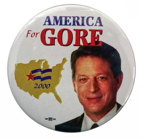 Round, white button with a color photograph of Al Gore and a gold outline of the United States. Blue and red text reads "AMERICA For GORE 2000"