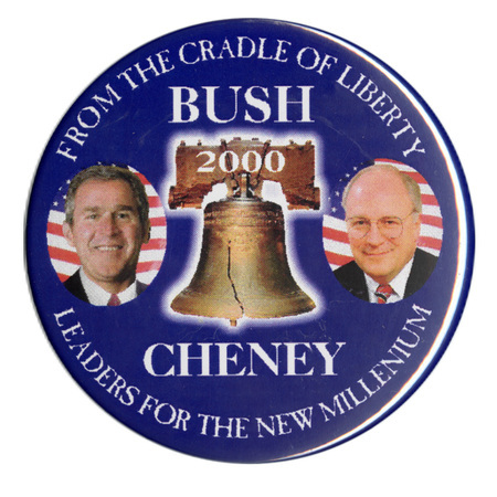 Round, blue button with color photographs of George W. Bush and Dick Cheney on either side of a color photograph of the Liberty Bell. White text reads "FROM THE CRADLE OF LIBERTY BUSH 2000 CHENEY LEADERS FOR THE NEW MILLENNIUM"