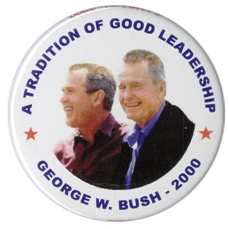 Round, white button with a color photograph of George W. and George H. W. Bush. Blue text reads "A TRADITION OF GOOD LEADERSHIP GEORGE W. BUSH 2000"