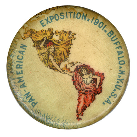 Round, white button with a color illustration of North America, depicted as a woman in a yellow gown, holding hands with South America, depicted as a woman in a red gown. Blue text reads "PAN-AMERICAN EXPOSITION 1901 BUFFALO NY USA"