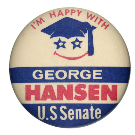 Round, white button with horizontal blue bands and an illustration of a smiley face below a blue mortarboard hat. Red and white text reads "I'M HAPPY WITH GEORGE HANSEN U.S. Senate"