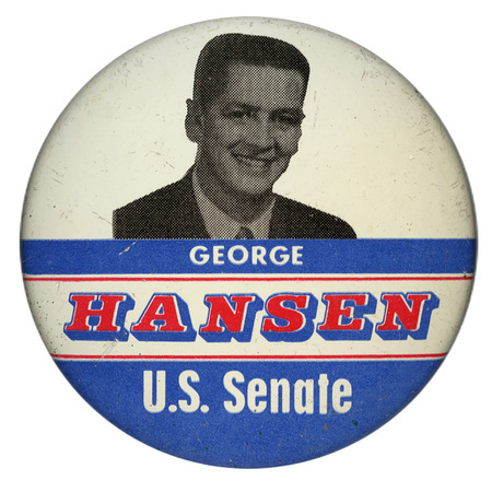 Round, white button with horizontal bands of blue. In the upper half is a black and white photograph of George Hansen. Below his photograph is white and red text reading "GEORGE HANSEN U.S. Senate"
