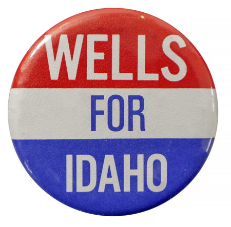 Round button with horizontal bands of red, white, and blue. White and blue text reads "WELLS FOR IDAHO"