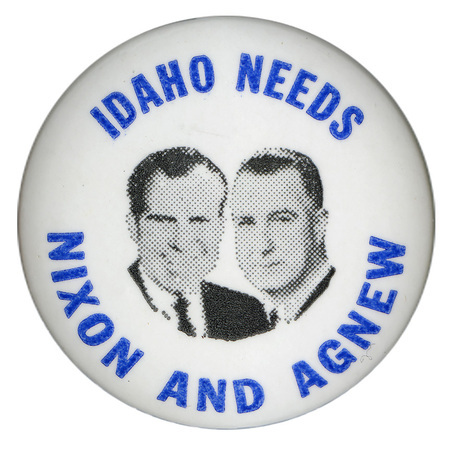 Round, white button with black and white photographs of Richard Nixon and Spiro Agnew. Blue text reads "IDAHO NEEDS NIXON AND AGNEW"