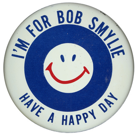 Round button with nested blue and white circles, in the center of which is a blue and red smiley face. Blue text reads "I'M FOR BOB SMYLIE HAVE A HAPPY DAY"