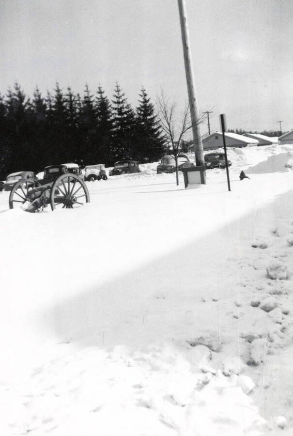 1939 photograph of cannons. Snow covered automobiles in background. [PG1_100-08]