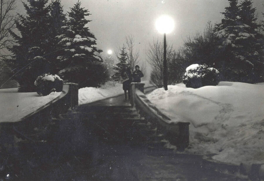 1931 photograph of the Hello Walk steps. Two students approach the steps on a snowy night. [PG1_102-07]