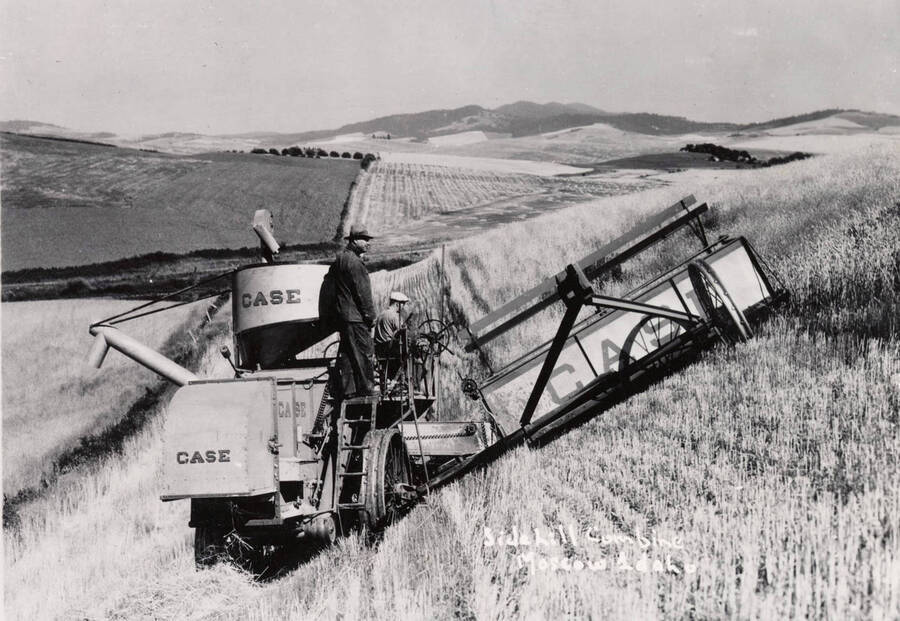 1940 photograph of University Farms. A side hill combine harvests a field. [PG1_105-13]
