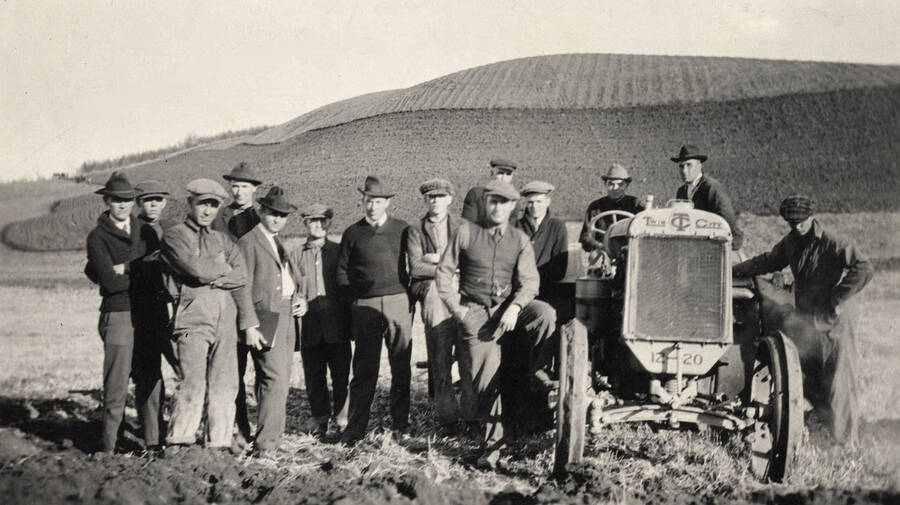 1932 photograph of University Farms. Students are grouped around a tractor. [PG1_105-02]