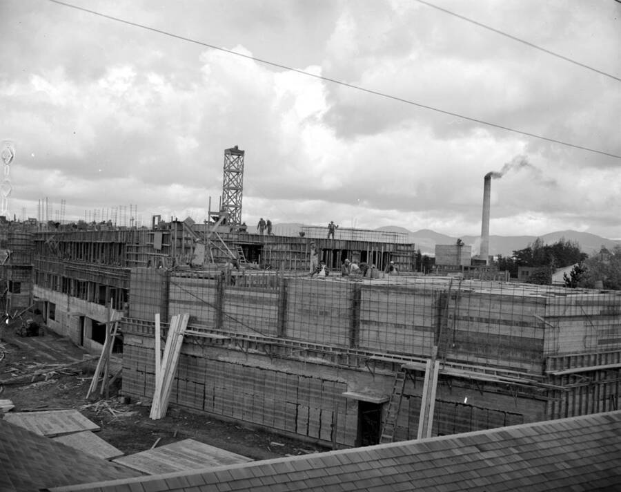 October 10, 1949 photograph of the Agricultural Science Building under construction. Construction workers in foreground, Power Plant in background. [PG1_111-19]