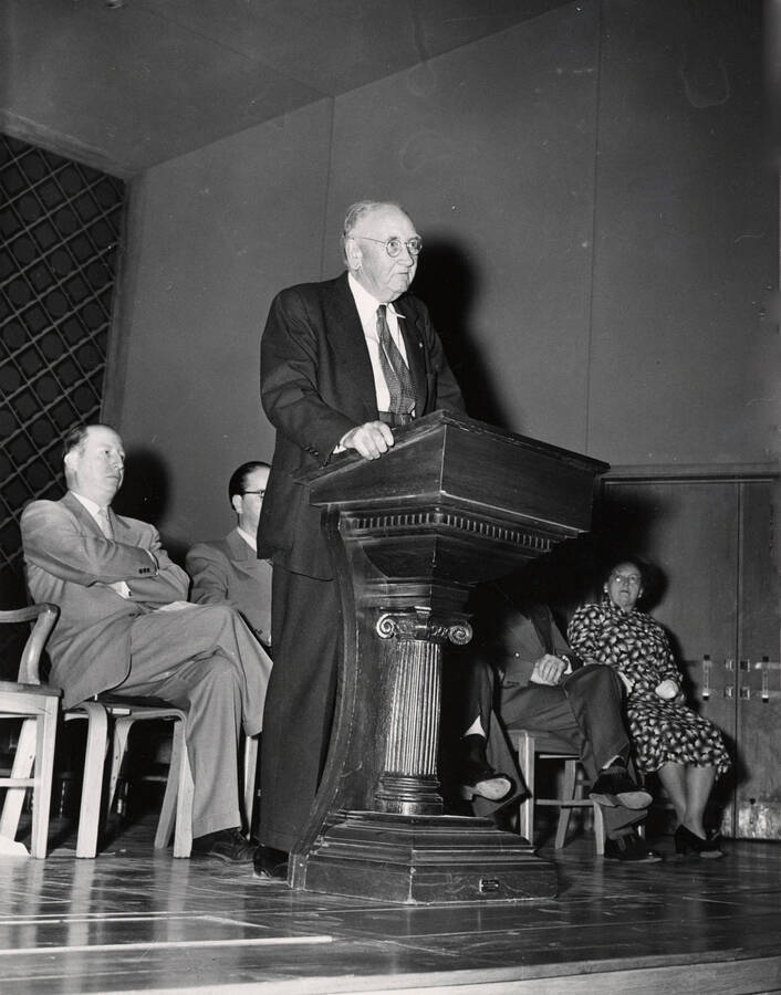 1952 photograph of Regent Mcnaughton at lectern in Music Building. Donor: Publications Dept. [PG1_117-10]