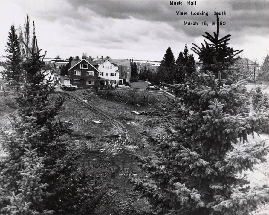 March 15, 1950 photograph of the Music Building under construction. Houses in background. [PG1_117-13b]