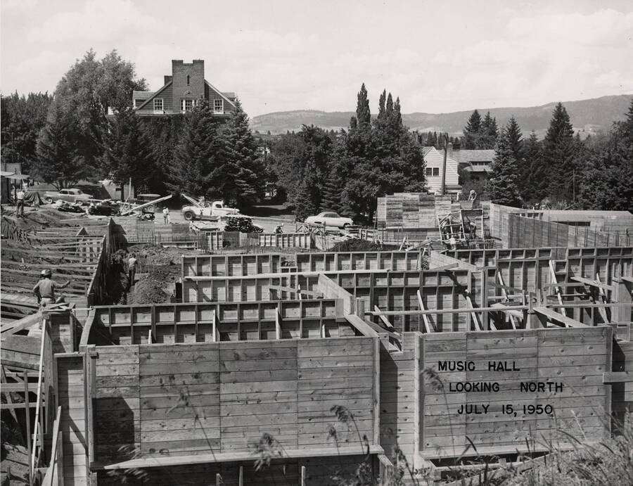 July 15, 1950 photograph of the Music Building under construction. Kappa Sigma house in the background. [PG1_117-15b]