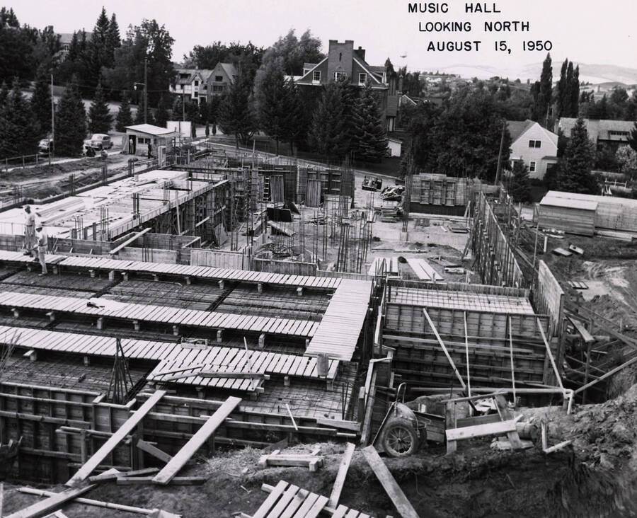 August 15, 1950 photograph of the Music Building under construction. Kappa Sigma house in the background. [PG1_117-16]